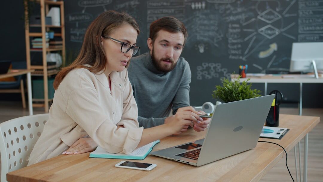 Startup team working together around a laptop in a modern office